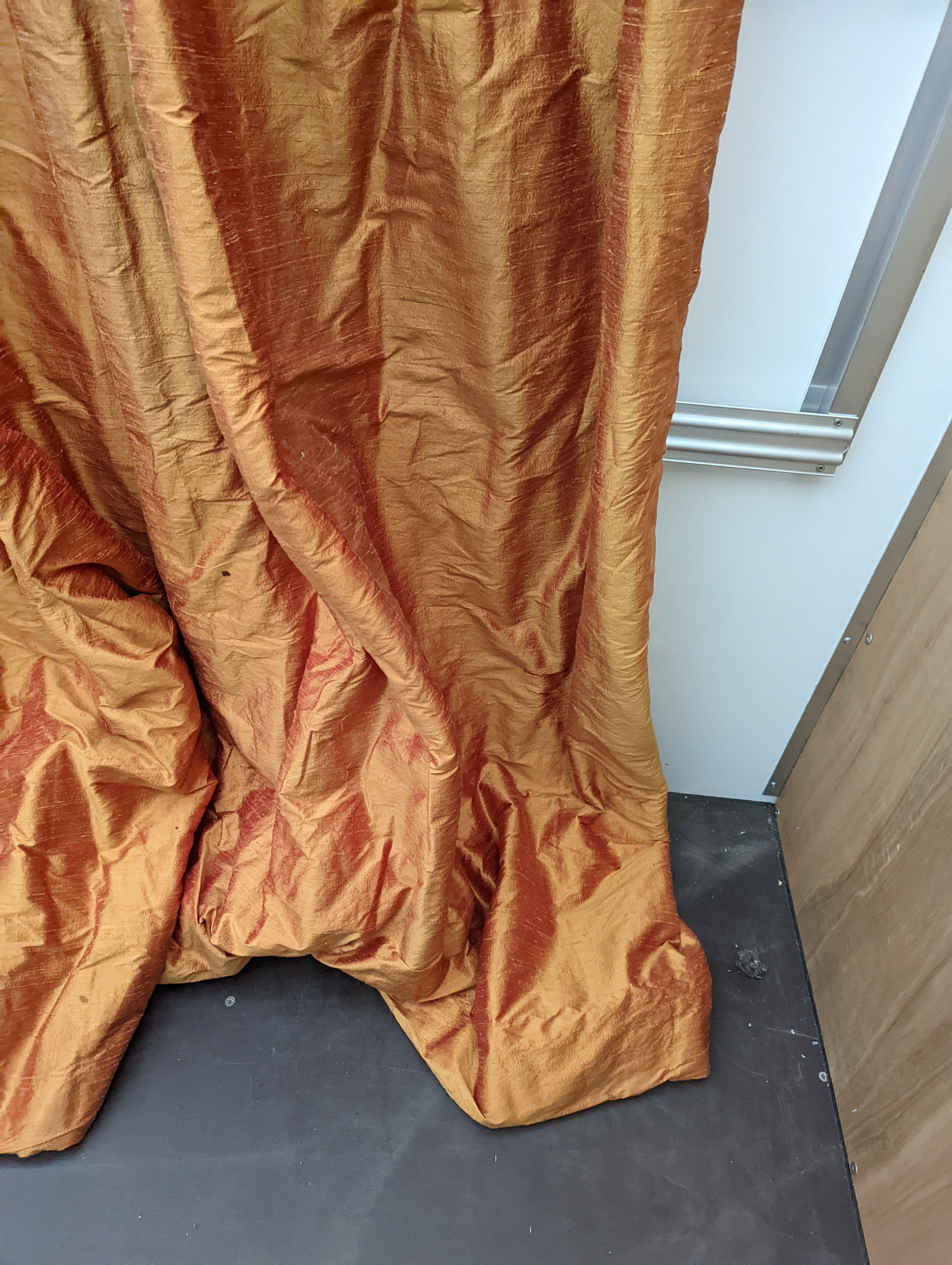 A pair of orange lined curtains. Approximate measurements: Width of top 180cm, Width of bottom 320cm Length 250cm
